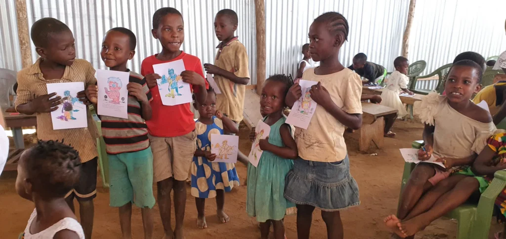 Children show their artwork after a workshop