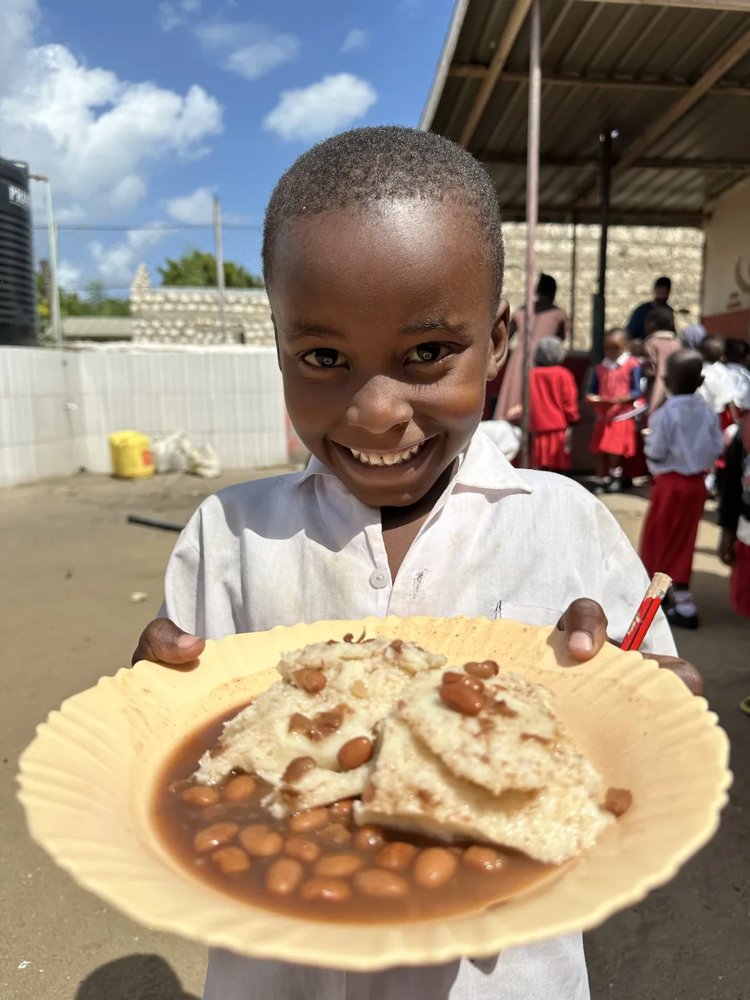 A Malindi Bring Life Academy student receives a daily meal of ugali and beans in Kenya