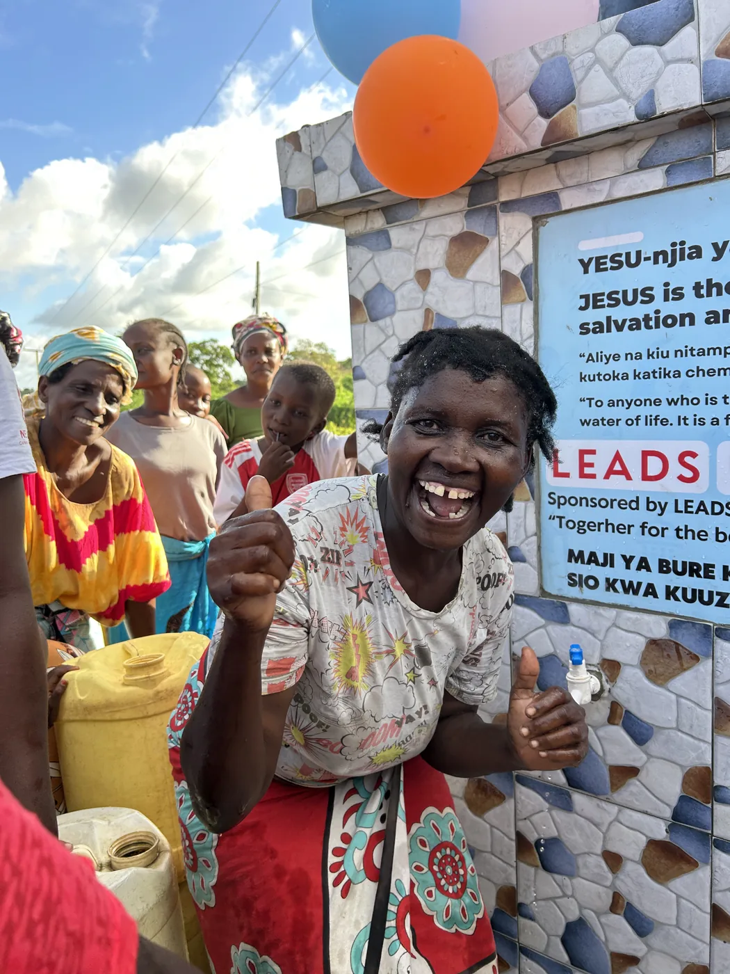 A woman drinks clean water at the opening of a new Bring Life Mission well in Kenya