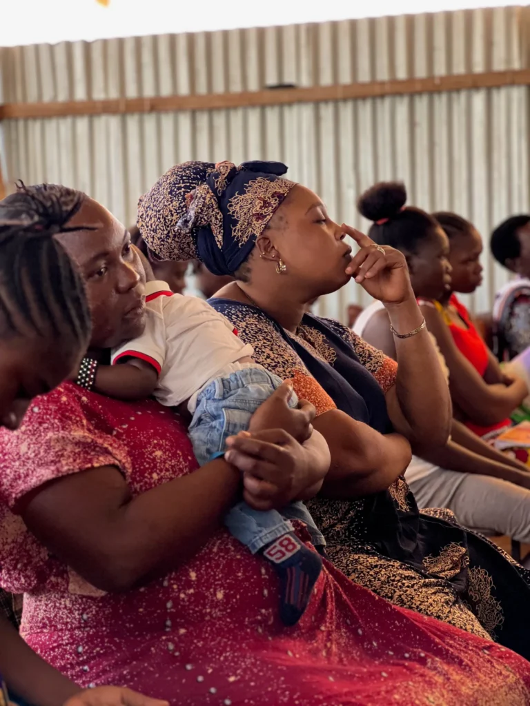 A mother with her baby listens closely to the sermon