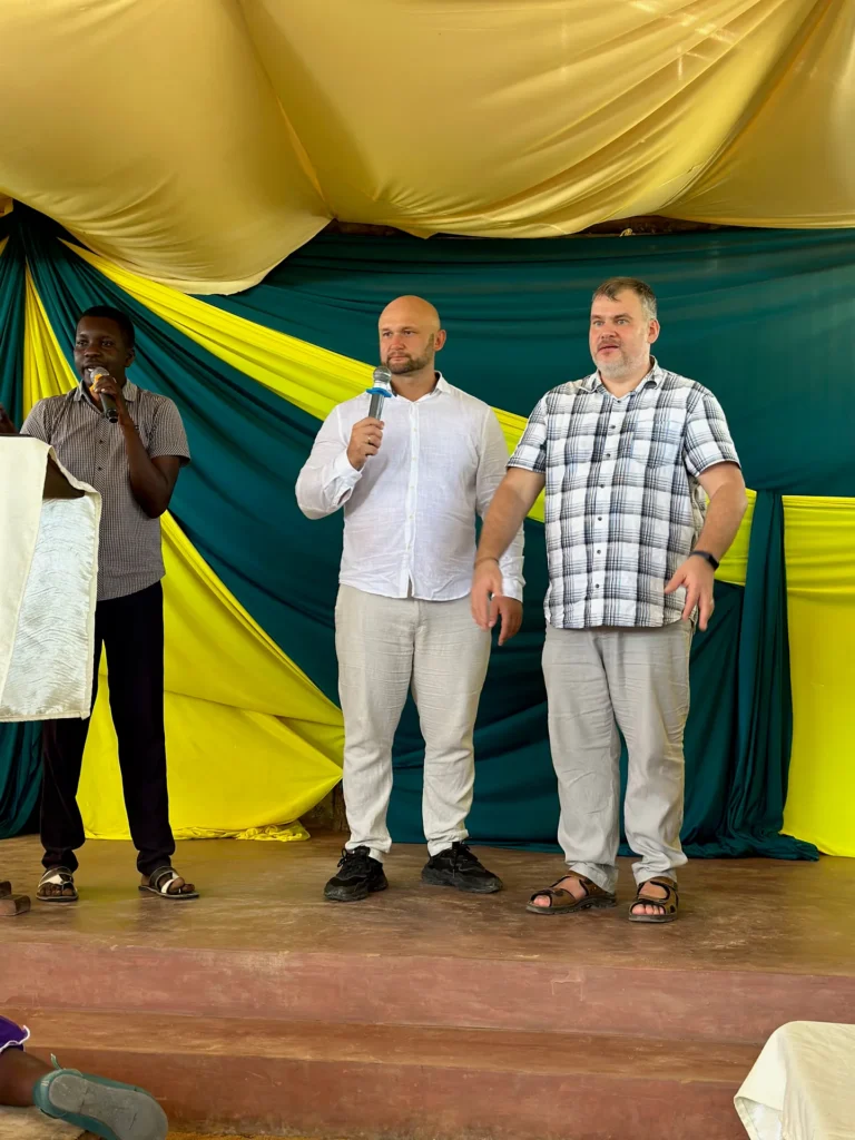 Dzianis Laptseikin and Evgeny Ageev minister on stage as a local translator interprets into Swahili