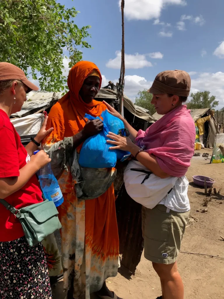Missionaries praying for a woman during outreach at a water well dedication in Kenya