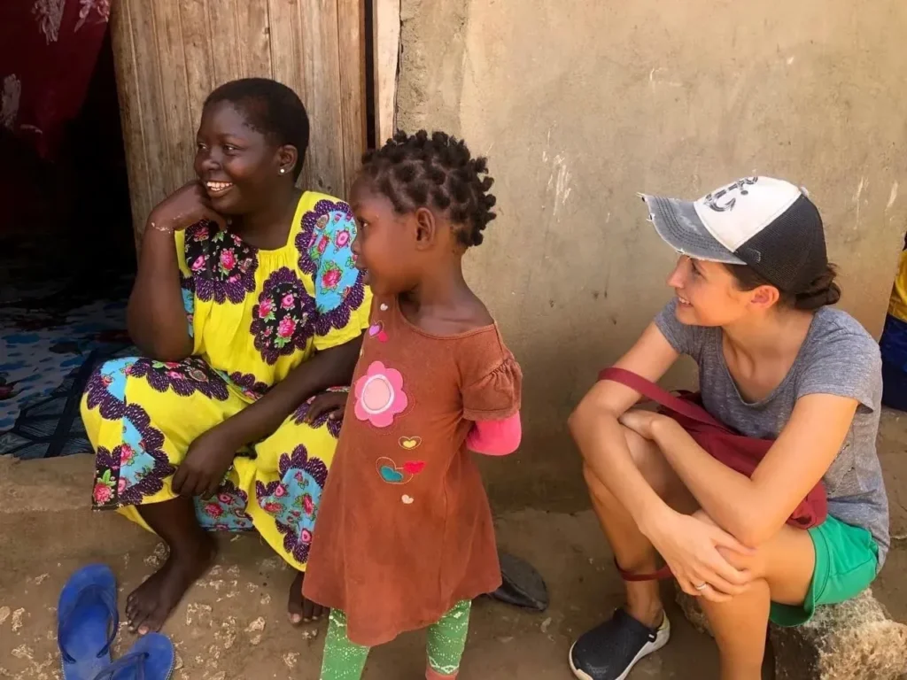 Bring Life Mission volunteer talking with a mother and child at the doorway of their home in Kenya