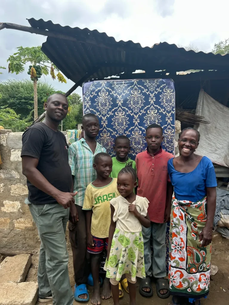 A mattress and groceries are presented to Eunice and her six children