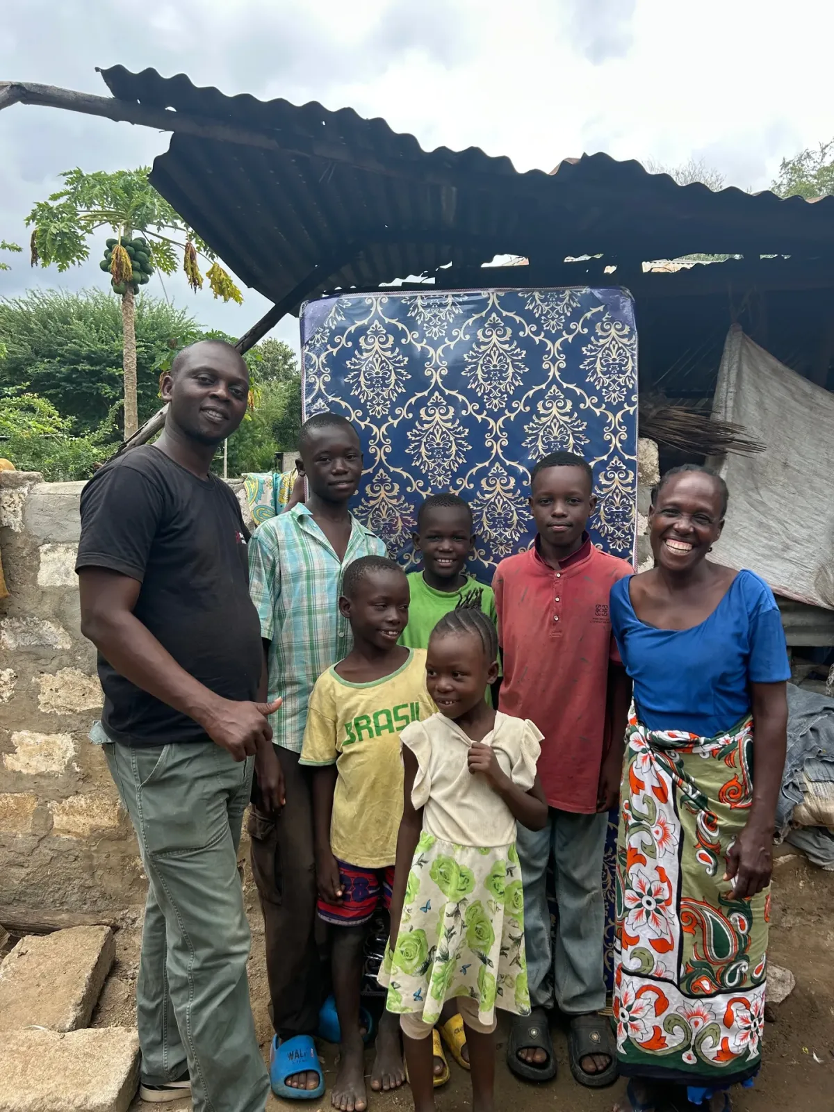 A mother of five children receiving groceries and a mattress from Bring Life Mission