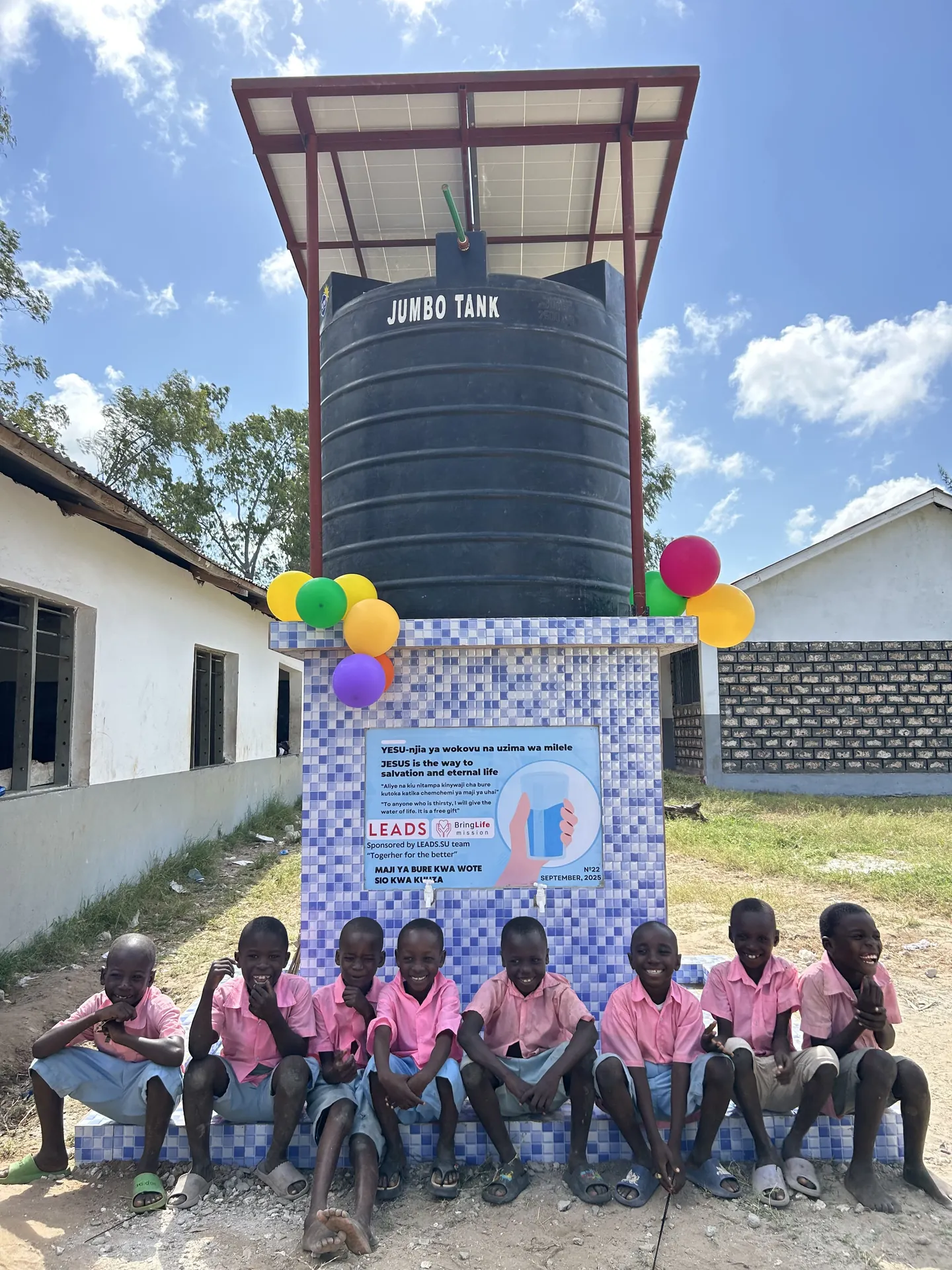 Children gather at a new Bring Life Mission water well on school grounds