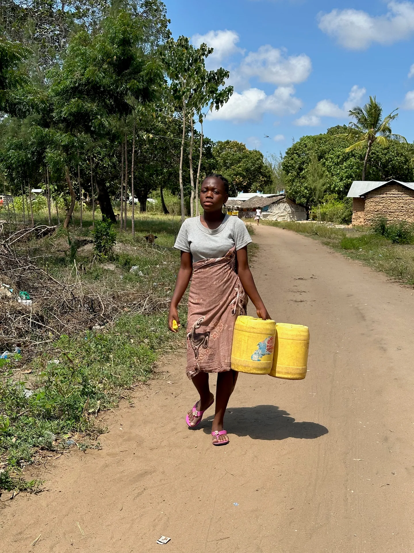 A woman collects water in Mlimani, where families once relied on a muddy pool
