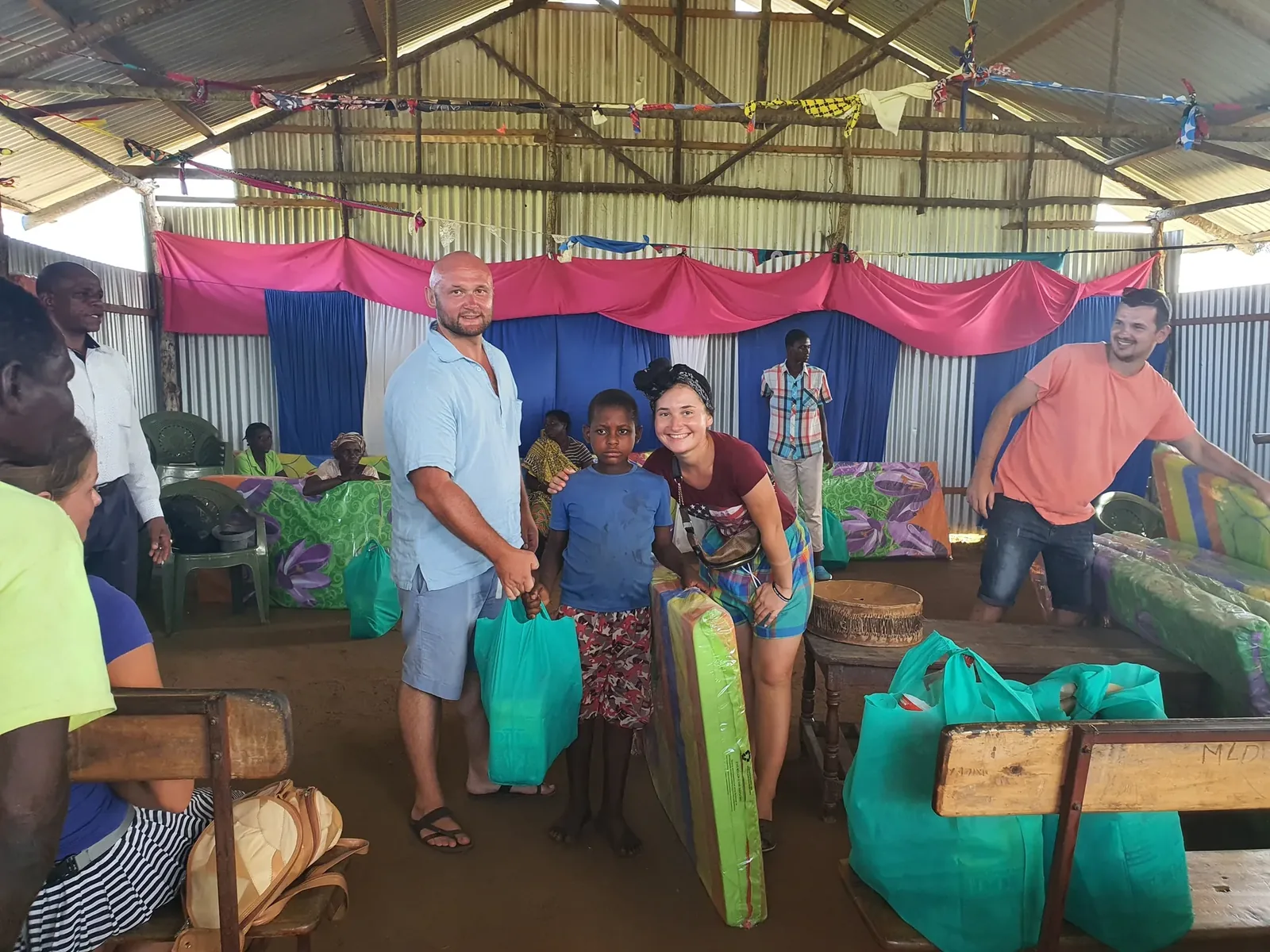 The mission team handing out school uniform kits to children