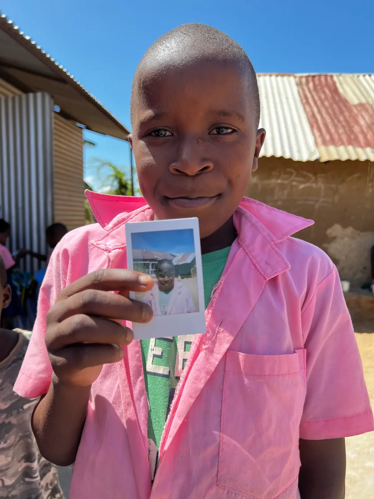 A boy showing his Polaroid photo