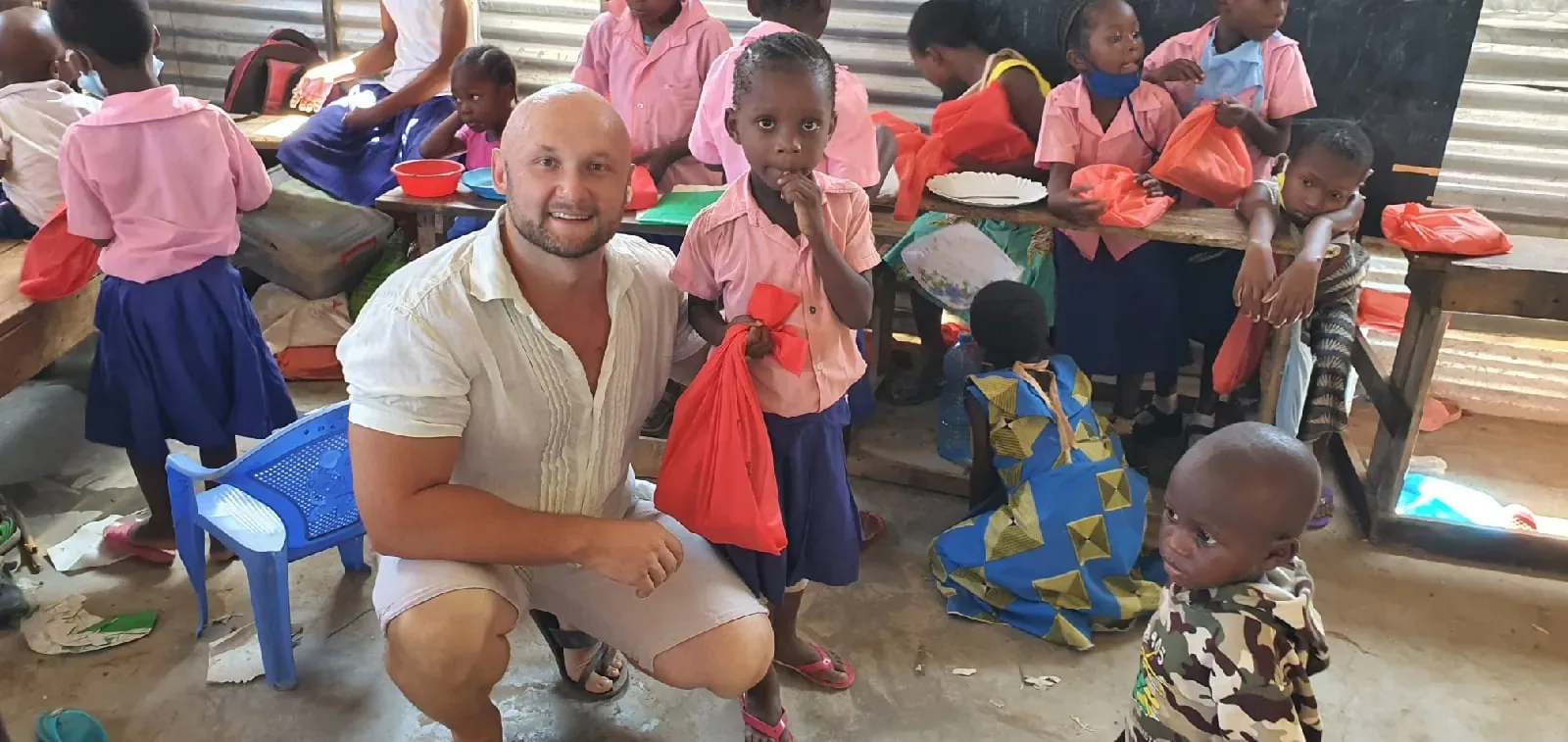 Handing out school supply kits to children in a classroom