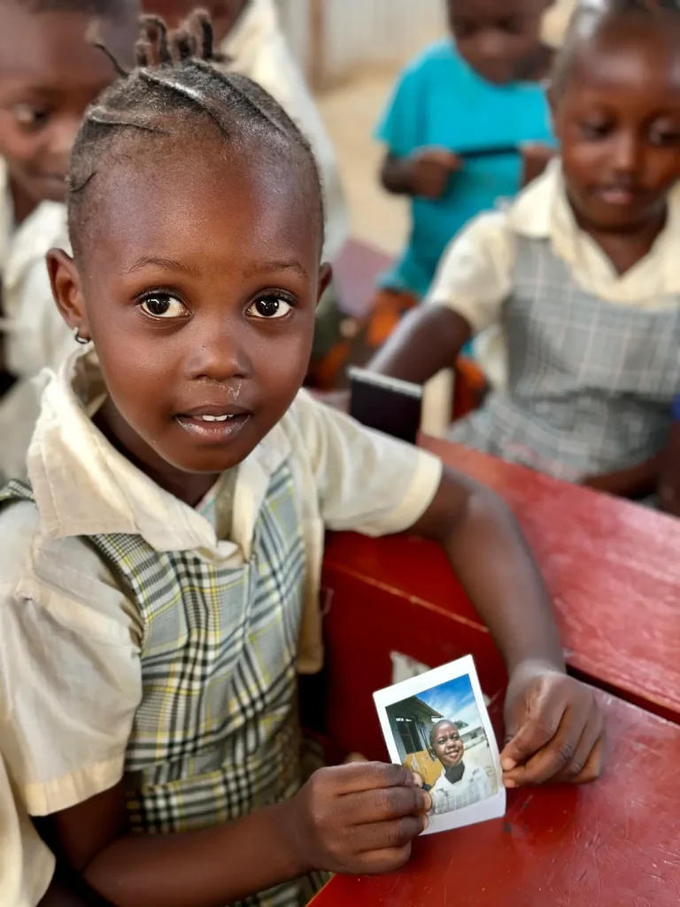 Ученица с полученной фотографией Polaroid за партой