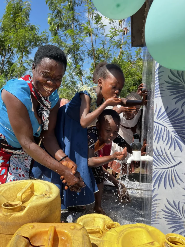 Residents drink clean water from a new Bring Life Mission well