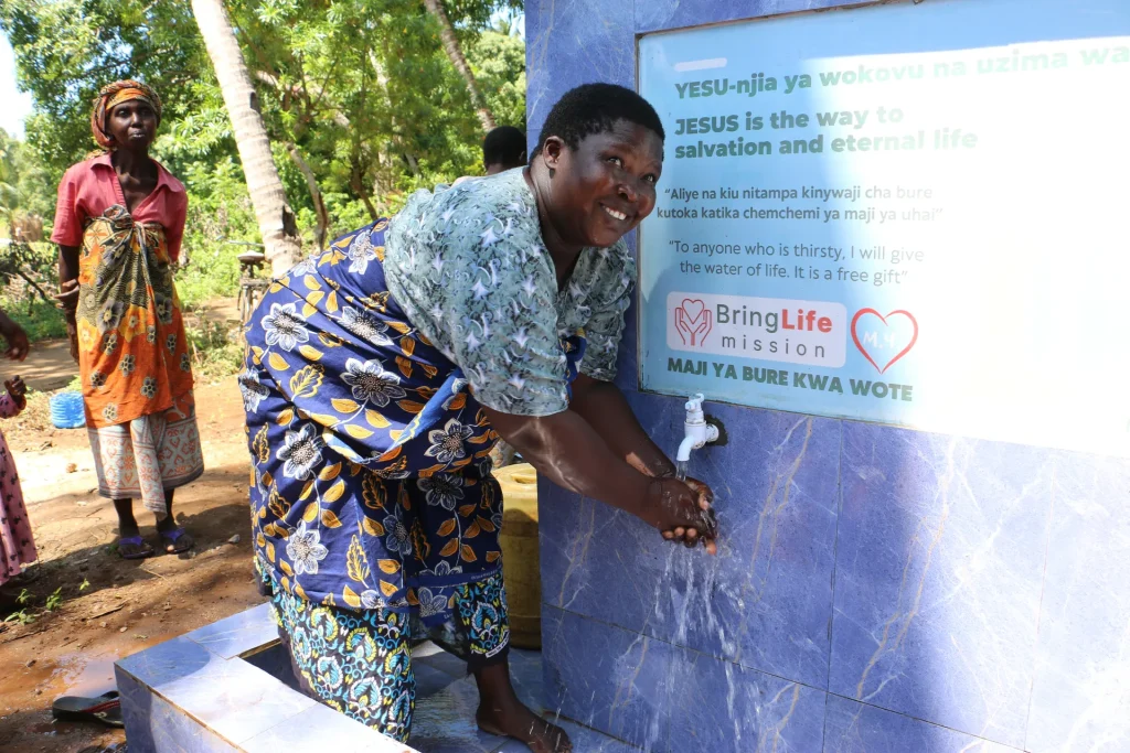 A woman washes her hands with clean water from a new well
