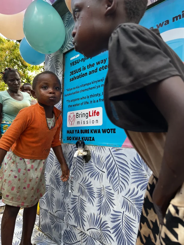 Children drink and collect water from a new well