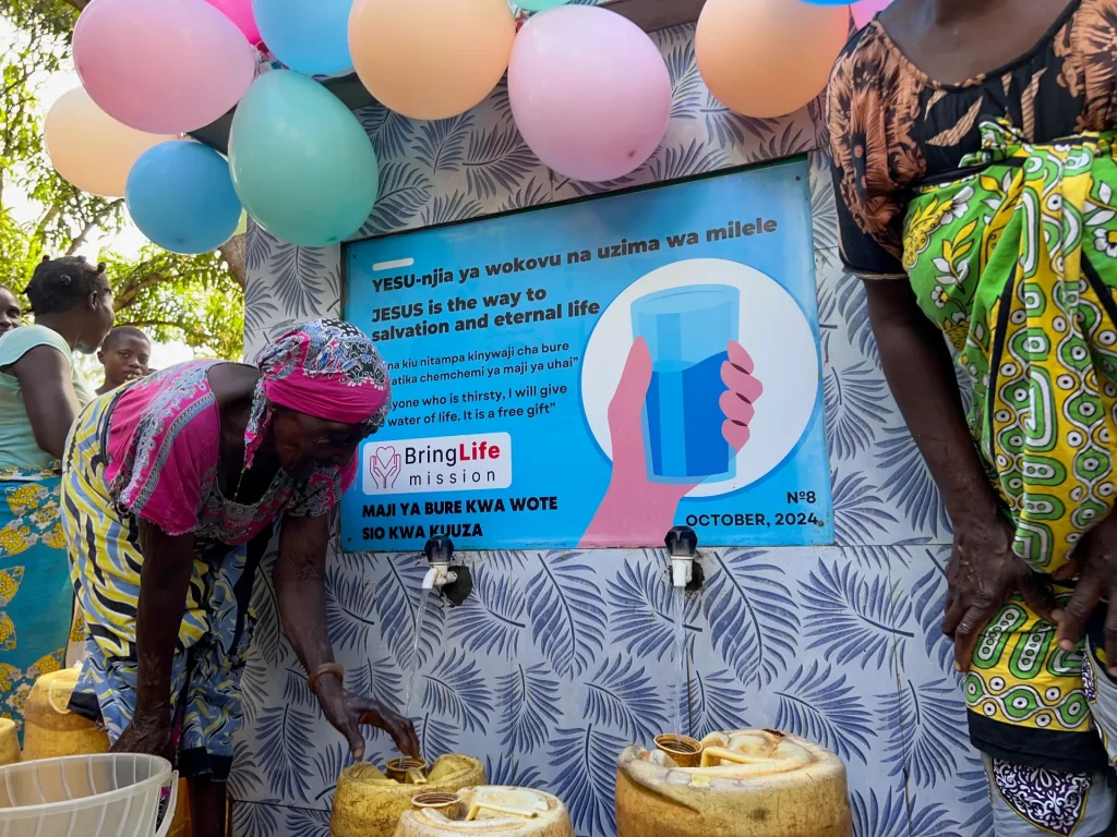 A community celebrates as clean water flows from a new well