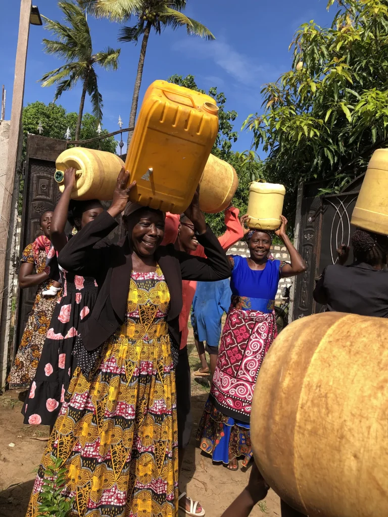 Women carry containers to a new water well