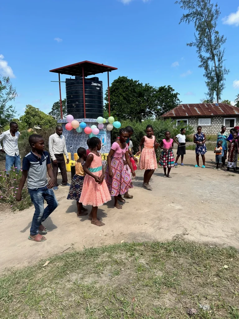 Residents celebrate and dance at a well opening