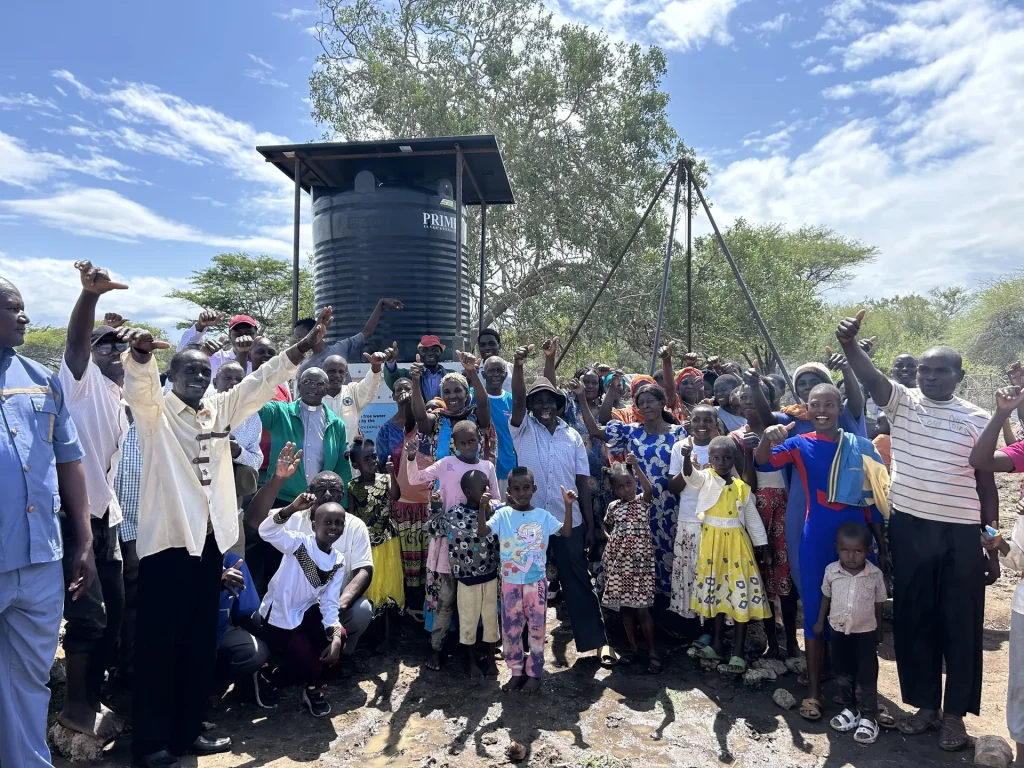 Community members celebrate beside their new water well