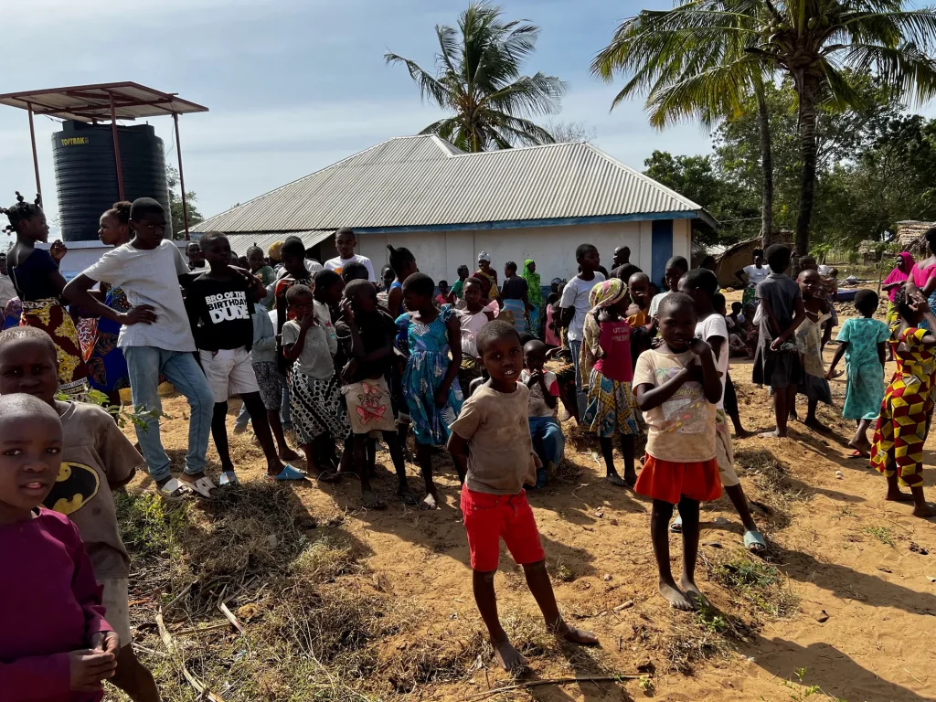 Residents wait for the first clean water from a new well
