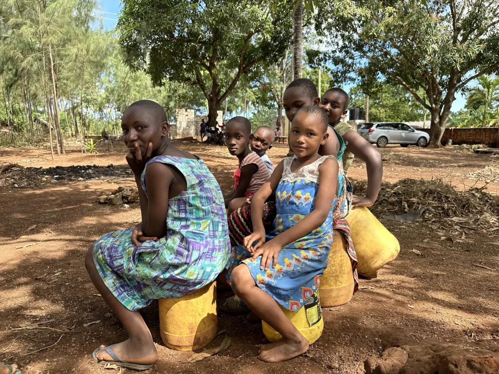 Children wait for the first clean water from a new well
