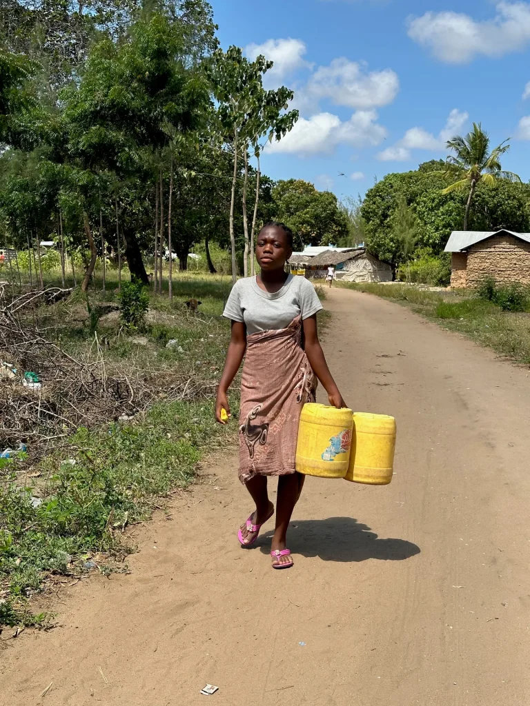 A woman collects water in Mlimani, where families once relied on a muddy pool